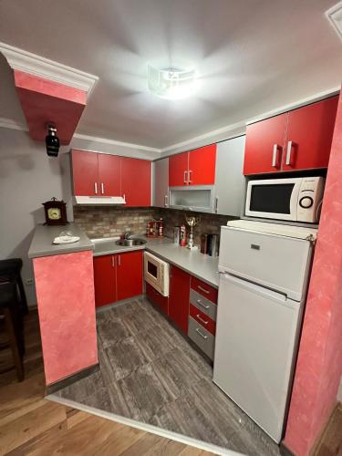 a kitchen with red cabinets and a white refrigerator at Migro Lux Centar in Arilje