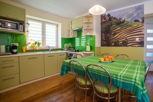una cucina verde con tavolo e ciotola di frutta di Willa Janka a Żegiestów