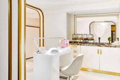 a white desk with a chair and a mirror at Carlton Cannes, a Regent Hotel in Cannes