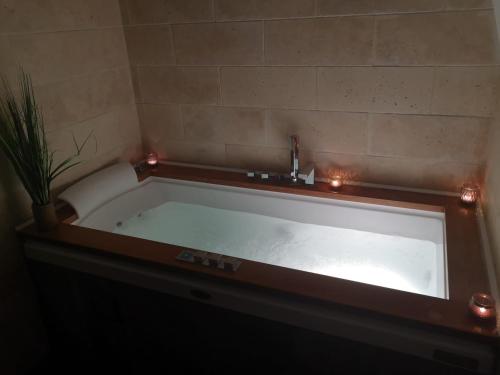 a large bath tub with lights in a bathroom at Jacuzzi® - La petite Romantique - FloBNB in Laon