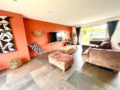 - un salon avec des murs orange et un canapé dans l'établissement Villa Malou 190m2 ,proche mer, à Outreau