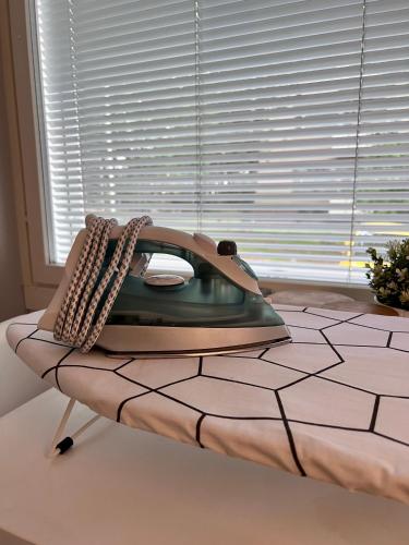 a phone sitting on a table next to a window at Kaksio Helsingissä omalla parkkipaikalla in Helsinki