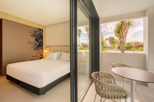 um quarto com uma cama, uma mesa e cadeiras em Eurostars Oasis Marbella em Marbella