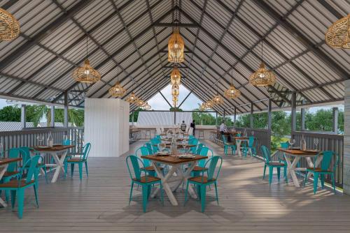 a dining area with tables and chairs and chandeliers at Praveg Beach Resort Daman, Jampore Beach in Daman
