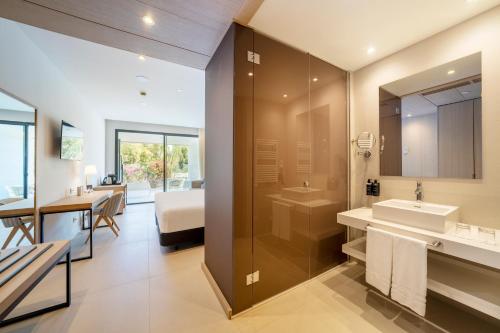 a bathroom with a sink and a shower and a bedroom at Eurostars Oasis Marbella in Marbella
