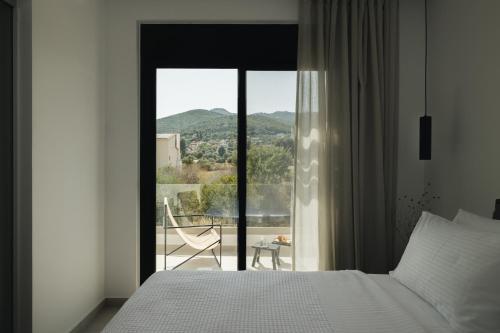 a bedroom with a bed and a view of a balcony at Ostrea Villas in Paleros