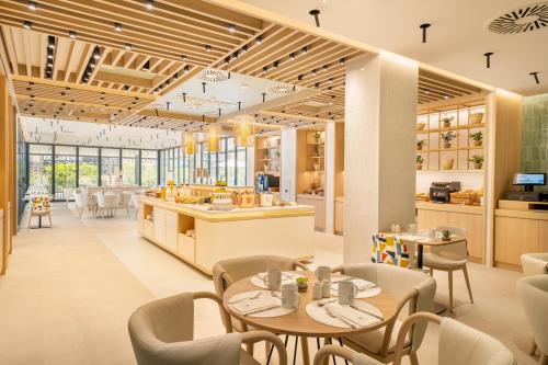 a restaurant with tables and chairs and a kitchen at Eurostars Oasis Marbella in Marbella
