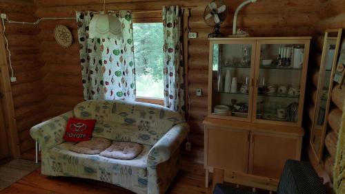a living room with a chair in a log cabin at Koivula Fish Cottage in Savonlinna