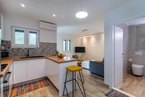 cocina y sala de estar con barra y taburete en A3 apt with balcony and sea view 3 min to beach, en Trogir
