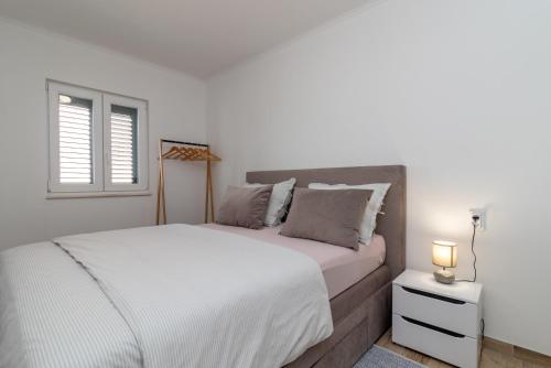 Un dormitorio blanco con una cama grande y una ventana en A3 apt with balcony and sea view 3 min to beach, en Trogir