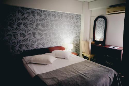 a bedroom with a bed with a patterned wall at Hotel Valahia in Târgovişte