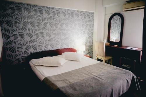 a bedroom with a bed with a patterned wall at Hotel Valahia in Târgovişte