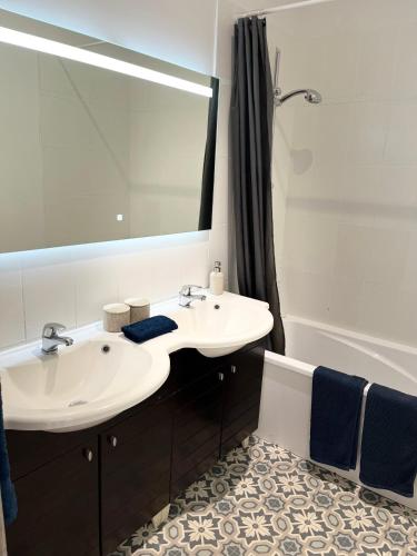 une salle de bain avec deux lavabos, un miroir et une baignoire dans l'établissement Bordeaux hypercentre - Grand Theatre - Opera - Parlement - Bourse, à Bordeaux