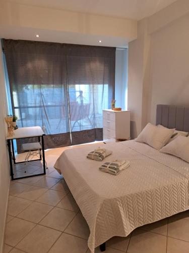 Schlafzimmer mit einem Bett, einem Schreibtisch und einem Fenster in der Unterkunft Hestia Airport House - Artemis in Artemida