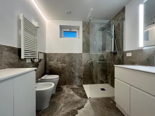 uma casa de banho com um WC, um lavatório e um chuveiro em Montecarlo Seaview Apartment em Chioggia