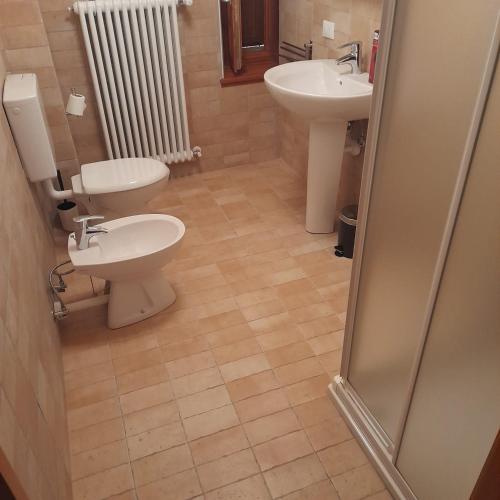 a bathroom with two toilets and a sink at Cjase Cjandin in Cercivento