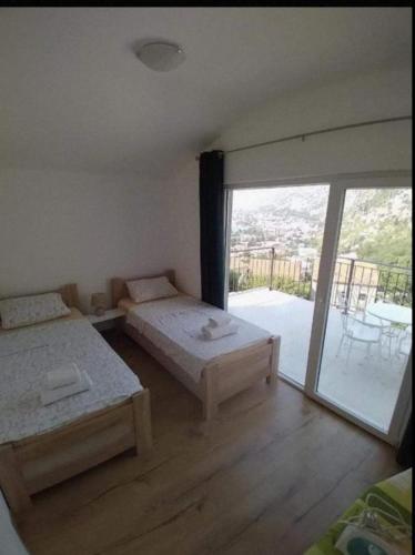 a bedroom with two beds and a sliding glass door at Apartments Marko Maros in Kotor