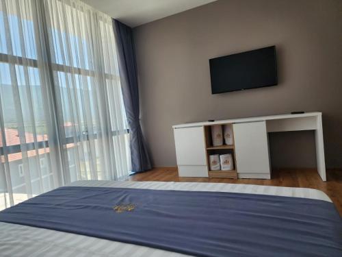 a bedroom with a bed and a tv on a wall at Imperador Palace Hotel Restorant in Peshkopi