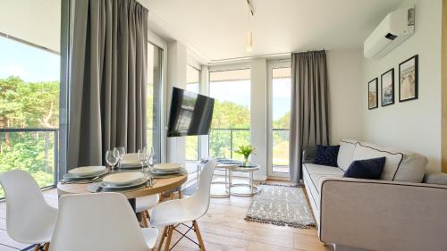 uma sala de estar com uma mesa e um sofá em Apartamenty Sun & Snow Lighthouse em Mrzeżyno