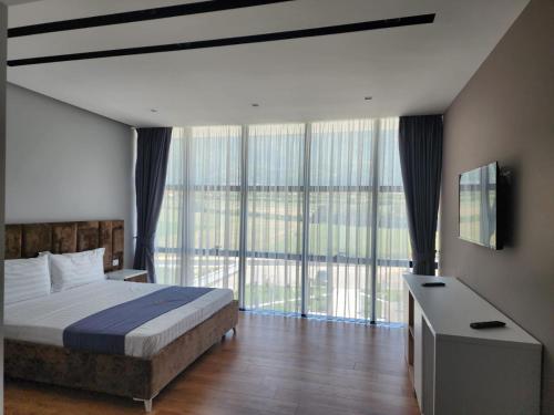 a bedroom with a bed and large glass windows at Imperador Palace Hotel Restorant in Peshkopi