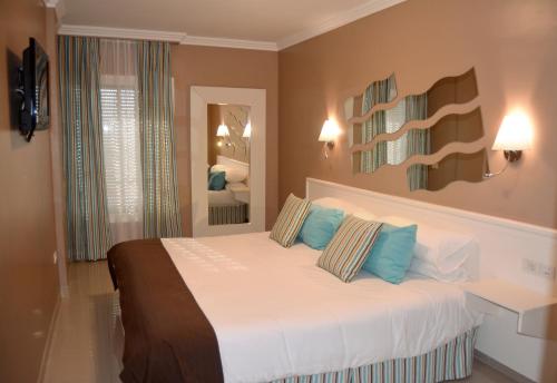 a bedroom with a large bed with blue pillows at Residencial La Quinta Park Suites in Santa Úrsula