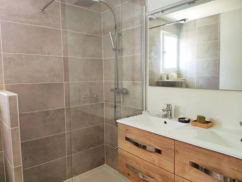 une salle de bain avec une douche avec un lavabo et un miroir dans l'établissement Joli haut de villa à deux pas de la mer et piscine, à Sausset-les-Pins