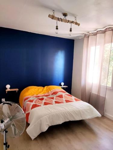 une chambre avec un lit et un mur bleu dans l'établissement Joli haut de villa à deux pas de la mer et piscine, à Sausset-les-Pins