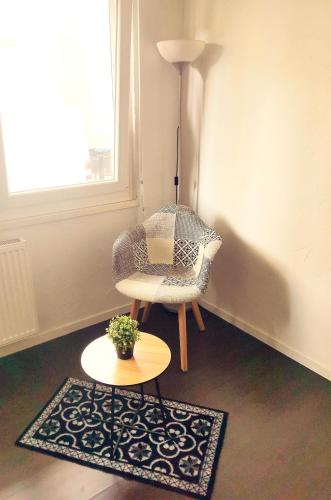 a room with a chair and a table and a lamp at Cozy Studio Strasbourg in Strasbourg