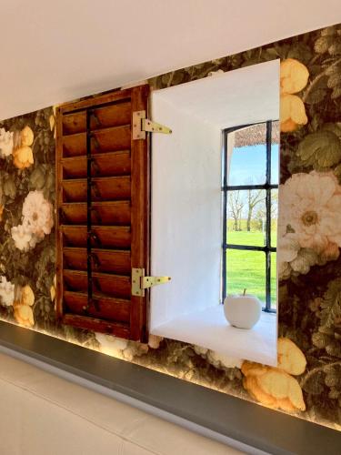 a mirror in a room with a window at Reetdachhaus, Sauna, E-Bikes, 6 Personen in Osterhever