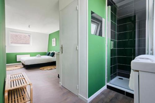 La salle de bains est pourvue de murs verts et d'une douche. dans l'établissement NG SuiteHome - Lille I Roubaix Jouffroy - Netflix - Wifi, à Roubaix