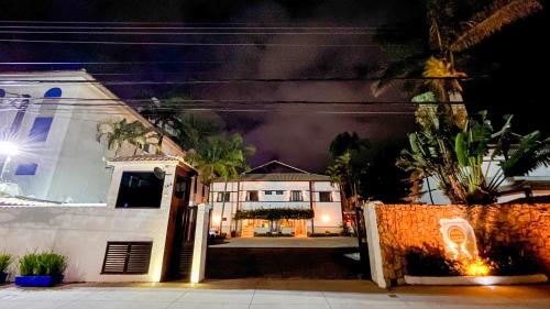 a house with a fence in front of it at night at Hotel Ilhas da Grécia in Guarujá