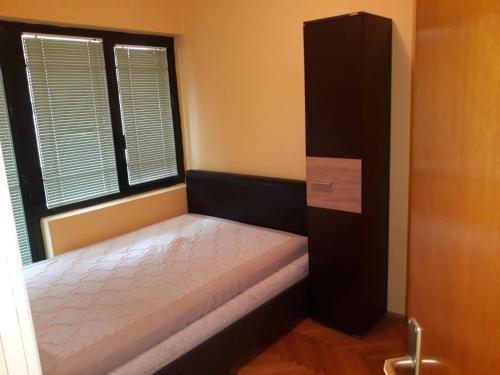 a small bedroom with a bed and a window at Bulevar apartment Budva in Budva