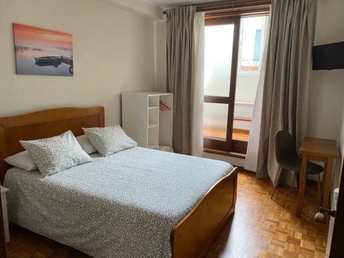 um pequeno quarto com uma cama e uma janela em Rêve D'Or na Póvoa do Varzim