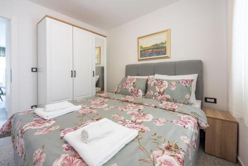 a bedroom with a bed with pink flowers on it at Villa Lucia 2 in Dramalj