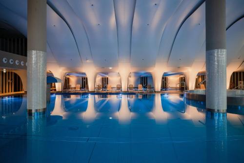 斯维诺乌伊希切Hilton Swinoujscie Resort And Spa的蓝色灯光的酒店游泳池