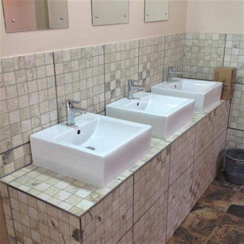 a bathroom with two sinks and two mirrors at TangleWood Nature Estate in Potchefstroom
