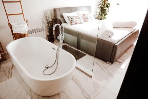 La salle de bains est pourvue d'une baignoire à côté d'un lit. dans l'établissement Holiday House Sunset Spa, à Šentjernej