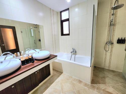 a bathroom with two sinks and a bath tub at The Peaberry Boutique Hotel in Chiang Mai