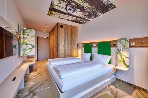 ein Schlafzimmer mit einem großen Bett in einem Zimmer in der Unterkunft Explorer Hotel Garmisch in Farchant