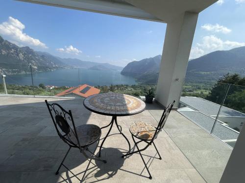 a table and chairs on a balcony with a view at IseoLakeRental - Wonder House in Solto Collina