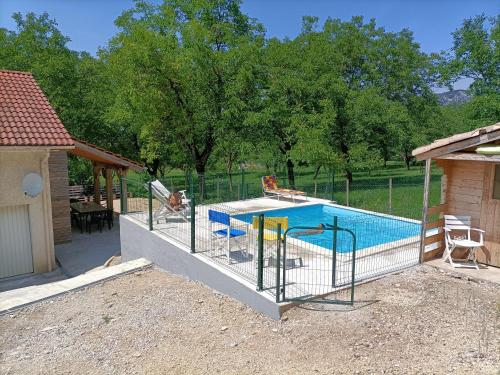 a swimming pool with a fence around it at La maison dans les noyer in Sainte-Eulalie