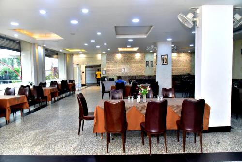 a dining room with a long table and chairs at Hotel Suraj Palace in Bhopal