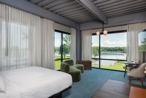 um quarto de hotel com uma cama e uma grande janela em voco James Newbury Hudson Valley, an IHG Hotel em Coxsackie