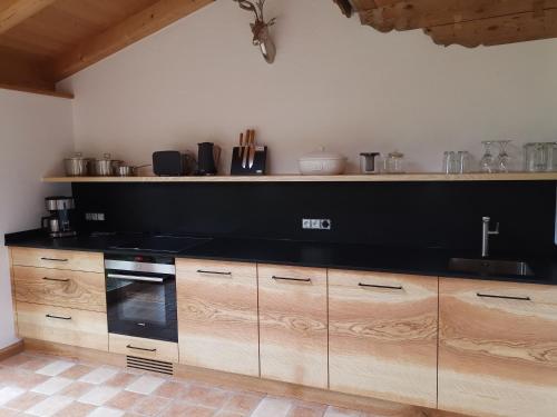 a kitchen with wooden cabinets and a black counter top at Landhaus Am Arzbach in Bad Tölz