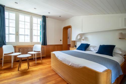 - une chambre avec un grand lit et deux chaises dans l'établissement Casa Margaux by PortofinoHomes, à Portofino