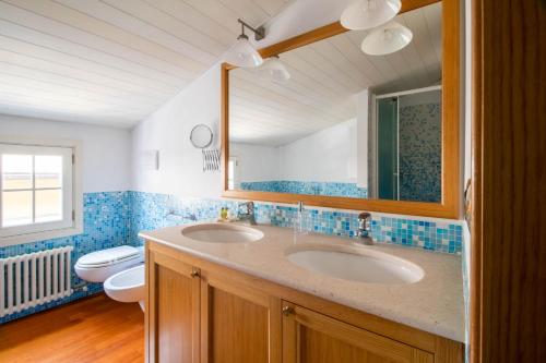 La salle de bains est pourvue de 2 lavabos, de toilettes et d'un miroir. dans l'établissement Casa Margaux by PortofinoHomes, à Portofino