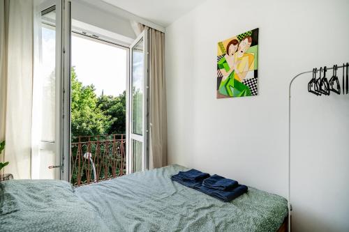 1 dormitorio con cama y ventana grande en Green Apartament Olsztyn, en Olsztyn