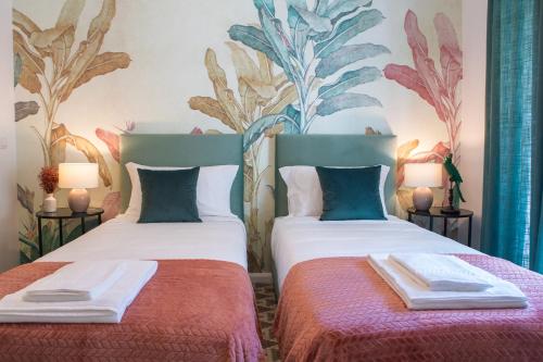 two beds in a room with a mural on the wall at Succeed Campo Pequeno Suites in Lisbon