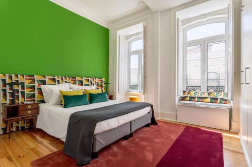 um quarto com paredes verdes e uma cama com um tapete vermelho em JOIVY Exquisite apt with patio in Graça em Lisboa