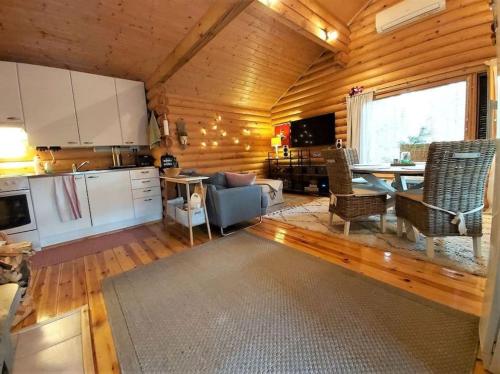 cocina y sala de estar con sofá y mesa en Unique winter holiday in pine forest, en Forssa